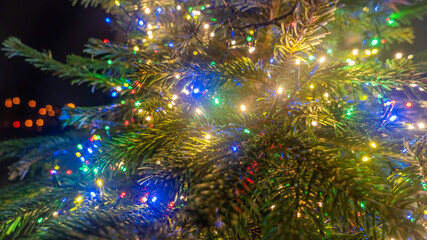 Obraz na płótnie Canvas Close-up image of illuminated christmass trees with garland. Lights and balls on defocused background. Christmas concepts. Xmas background. Space for text.