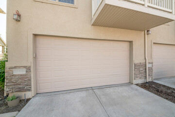 Beige sectional garage doors of a townhouses with balcony