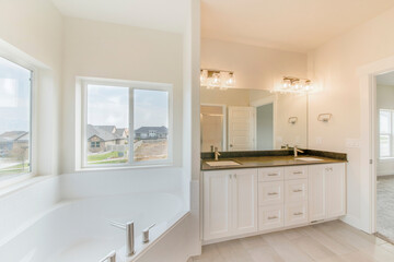 Fototapeta na wymiar Contemporary masters bathroom with sliding windows in all white