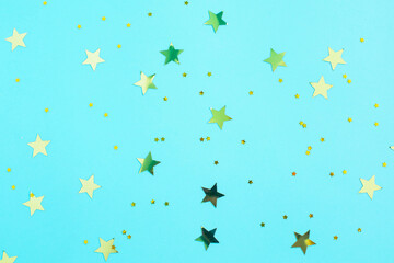 Gold glitter stars decorations on blue background.