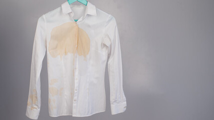Women's office white shirt with a stain of coffee on a white background.