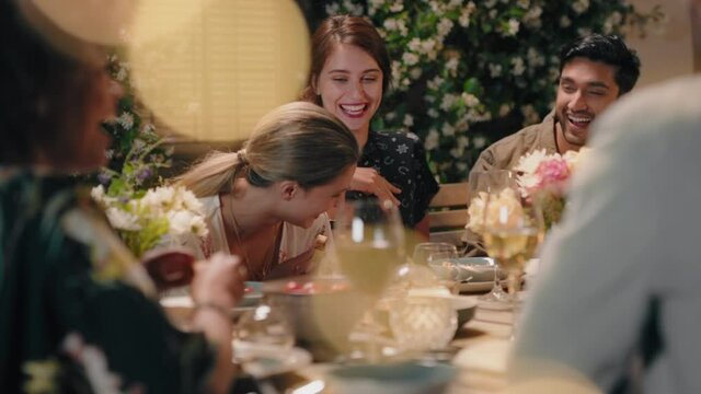 group of friends celebrating evening dinner party sharing homemade meal enjoying casual conversation having fun weekend reunion relaxing on calm summer night outdoors 4k footage