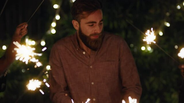 new years celebration friends with sparklers sharing holiday celebration together having fun party evening in home backyard at night 4k