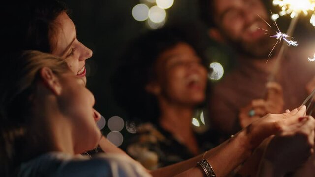 new years celebration friends with sparklers sharing holiday celebration together having fun party evening in home backyard at night 4k