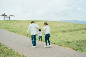 Obraz premium 手を繋いで歩く家族（後ろ姿） 