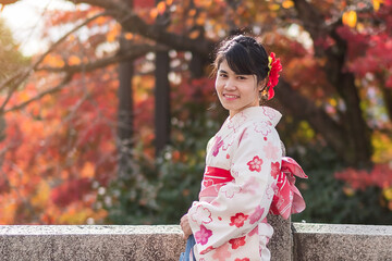 young woman tourist wearing kimono enjoying with colorful leaves in temple, Kyoto, Japan. Asian...