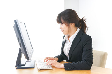 オフィスでコンピューターを使うビジネスウーマン