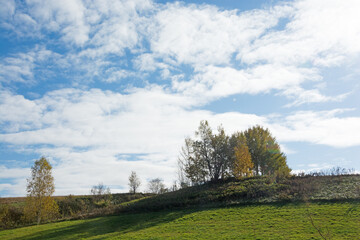 秋の青空と緑の丘
