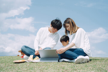 空とタブレットPCを使う家族 