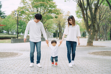 手を繋いで歩く家族（ジャンプ）
