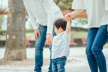 手を繋いで歩く家族
