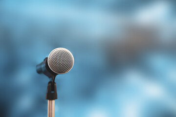 Microphone Public speaking background, Close-up the microphone on stand for speaker speech presentation stage performance with blur and bokeh light background.