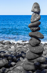 Fototapeta na wymiar Empilement de pierres sur plage de galets, Anse des Cascades, île de la Réunion 