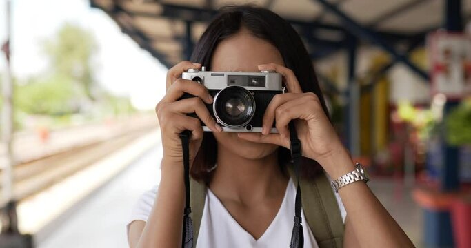 Woman taking a photo at train station