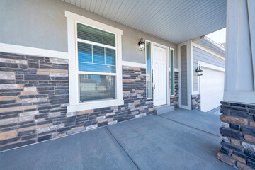 Front porch of a house with white front door and two side panels