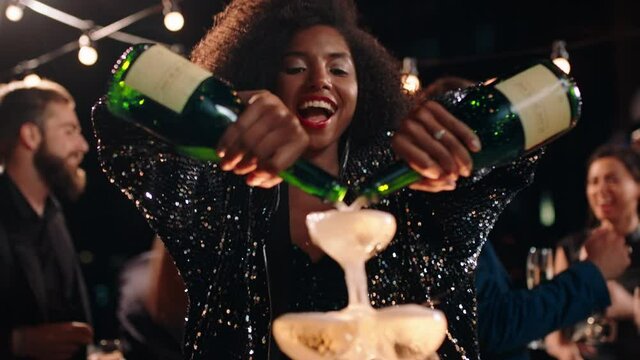 happy celebration woman pouring champagne tower at glamorous dance party celebrating with friends enjoying crazy nightlife wearing stylish fashion dancing on rooftop at night 4k footage