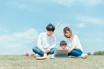 空とパソコンを使う家族
