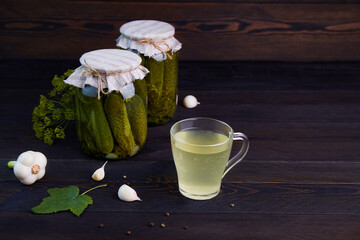 Pickled cucumbers in a jars on a dark wooden background. Homemade marinated cucumbers. 