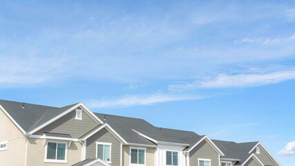 Pano Front view of townhouses against blue sky on a suburban neighborhood landscape