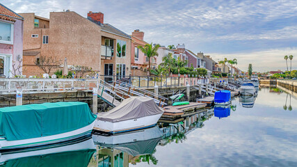 Fototapeta na wymiar Pano Boats on docks of canal along seaside houses in Huntington Beach Califonia