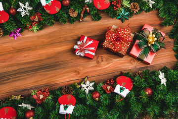 Fototapeta na wymiar Christmas background, border decorate with pine branches gift socks and festive ornaments, natural wood background copy space in middle are with three presents
