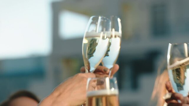 happy group of friends celebrating making toast to glamorous party event drinking champagne wearing stylish fashion at formal social gathering enjoying rooftop dance celebration at sunset 4k