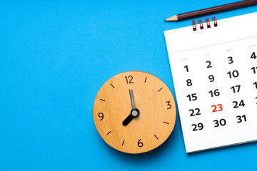 close up of calendar and clock on the blue table background, planning for business meeting or travel planning concept