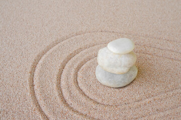 Fototapeta na wymiar Zen garden stone Japanese on raked sand. rock or pebbles on beach design outdoor for meditate peace of mind and relax. chan Buddhism religion concept.