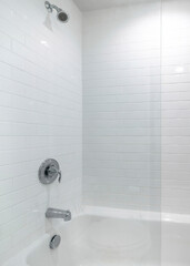 Vertical Alcove bathtub with glass wall divider and a wall with white tiles