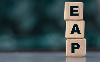 EAP - acronym on wooden cubes on a blurr gray background