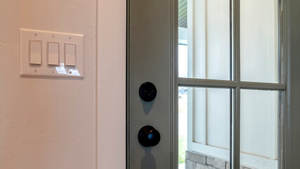 Pano Close up of wooden front door of home with glass panel and black doorknob