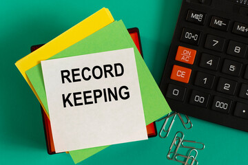 RECORD KEEPING - words on note paper against the background of a calculator and paper clips.