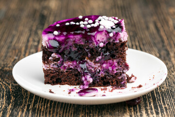 chocolate cake with cream covered with purple berry jam