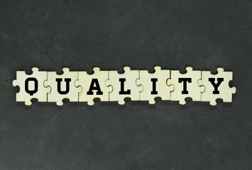 wooden puzzle with the word quality. conceptual quality