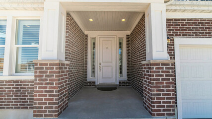 Pano Home entrance with portico and white front door flanked by narrow sidelights