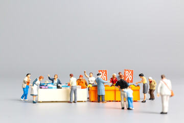 Miniature people , Shoppers with discount tray for shopping discounted items ,  Black friday concept