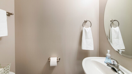 Pano Interior of a powder room with light mocha walls and sink