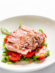 tuna fillet with salad on white plate