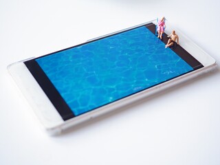 Miniature people relax at swimming pool.