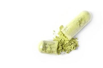 Closed up green Thai herb powder in capsule on white background. For natural medication or...
