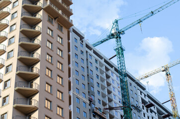 Construction of a multi-storey building. Construction crane. Apartment house.