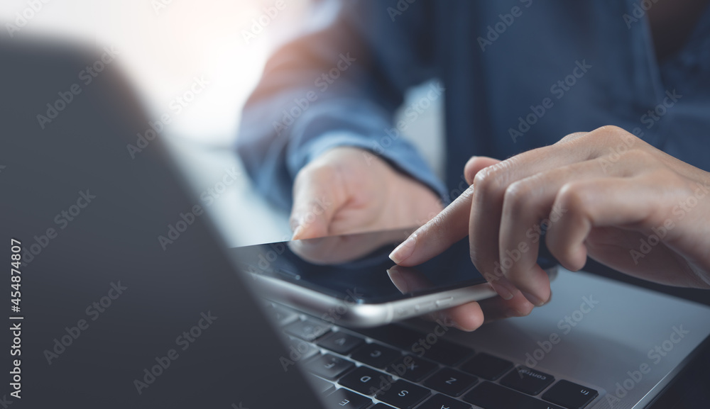 Wall mural close up of woman hand holding mobile phone and finger touching on screen, surfing the internet