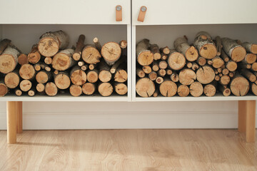 Stocks of firewood for the fireplace are stacked on the shelves. Background of dry chopped wood...
