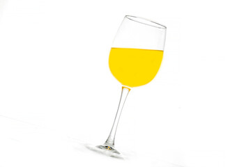 Crystal goblet with a yellow drink. Splash. Food. Design. Background