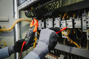 Electrical engineers test electrical installations and wiring on protective relays, measuring them...