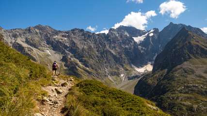 Montée d'un randonneur face aux Bans et ses glaciers dans les Alpes, ascent of a hiker facing the...