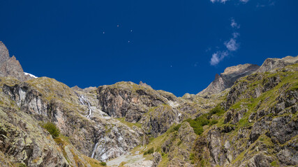 parapentes en vol au dessus des Alpes, Paragliders in flight over the Alps on a blue sky background