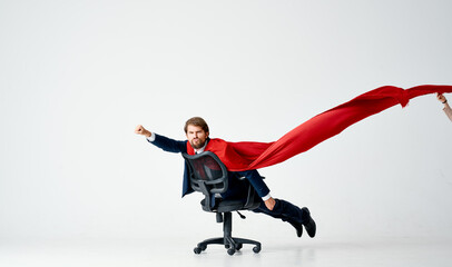 business man with red cloak trying in superman office chair