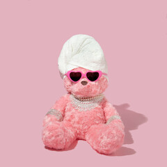 Creative layout with pink teddy bear with towel wrap, heart shaped sunglassess and luxury jewelry...