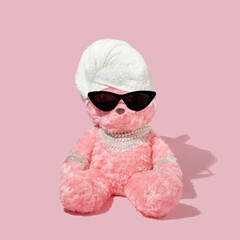 Creative layout with pink teddy bear with towel turban, black sunglassess and luxury jewels on...